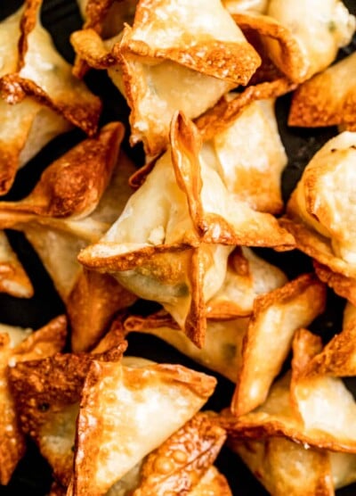 Closeup of crab rangoon piled on top of each other.