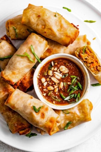 Air fryer spring rolls with peanut sauce on the side.