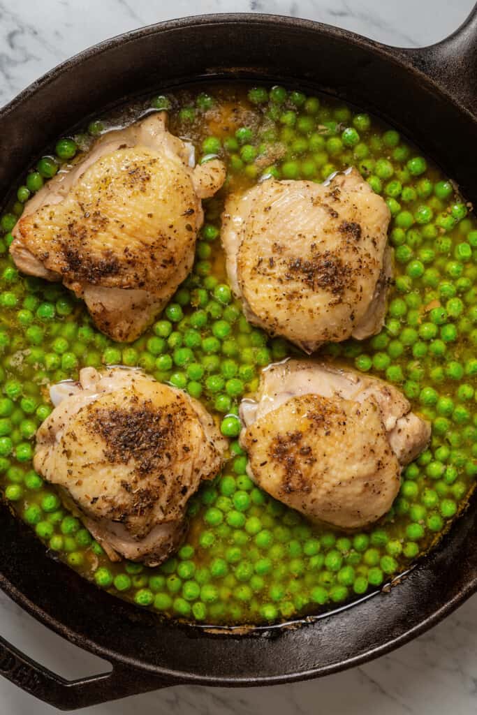 Chicken and peas in lemony sauce in a pan.