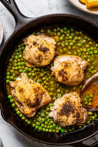 A skillet with Chicken and peas in lemon sauce to make Vesuvio.