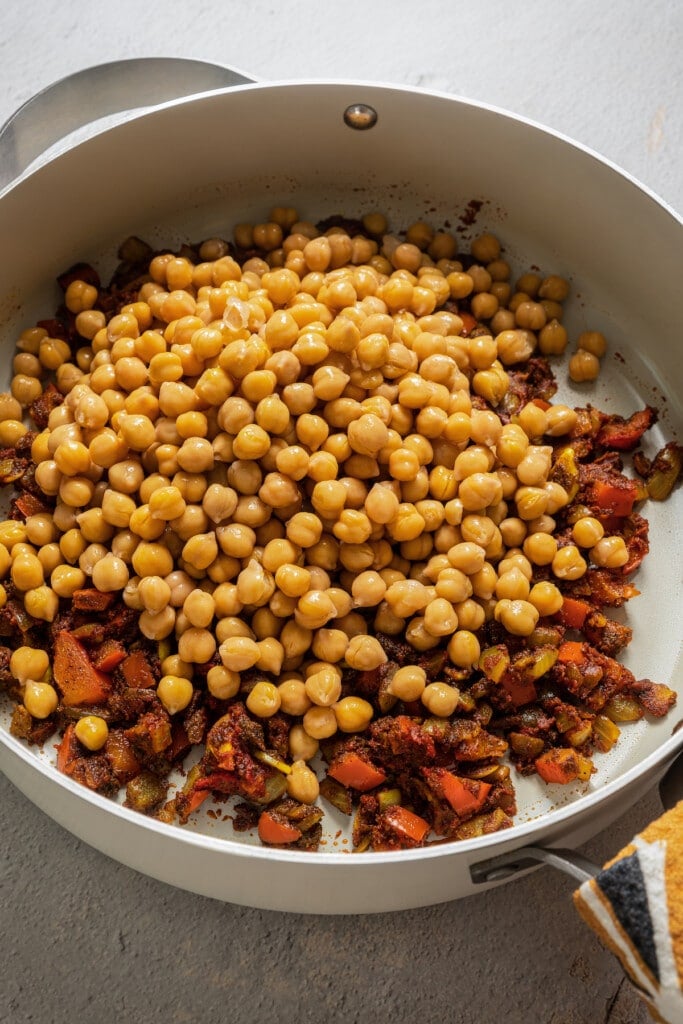 Toasting chickpeas with sauteed veggies, spices, and tomato paste.
