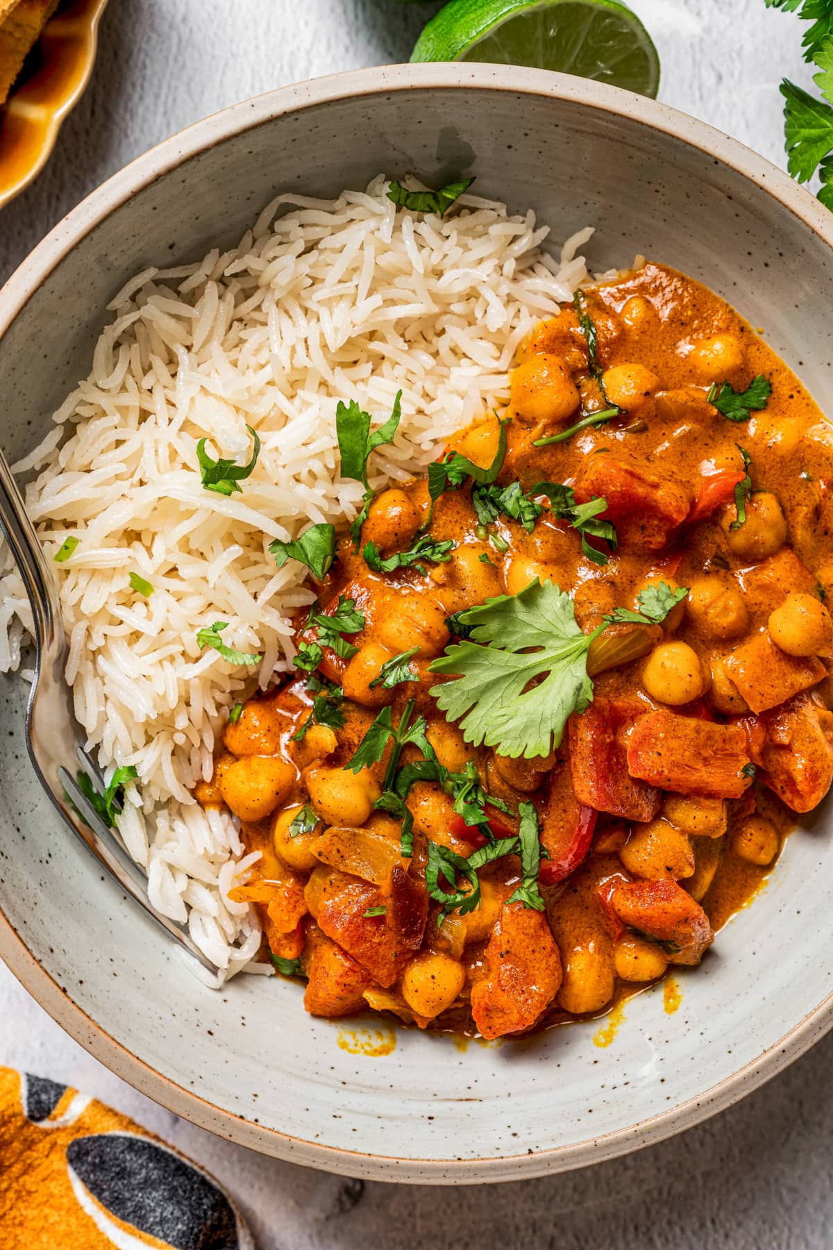 Coconut chickpea curry served over rice in a bowl.