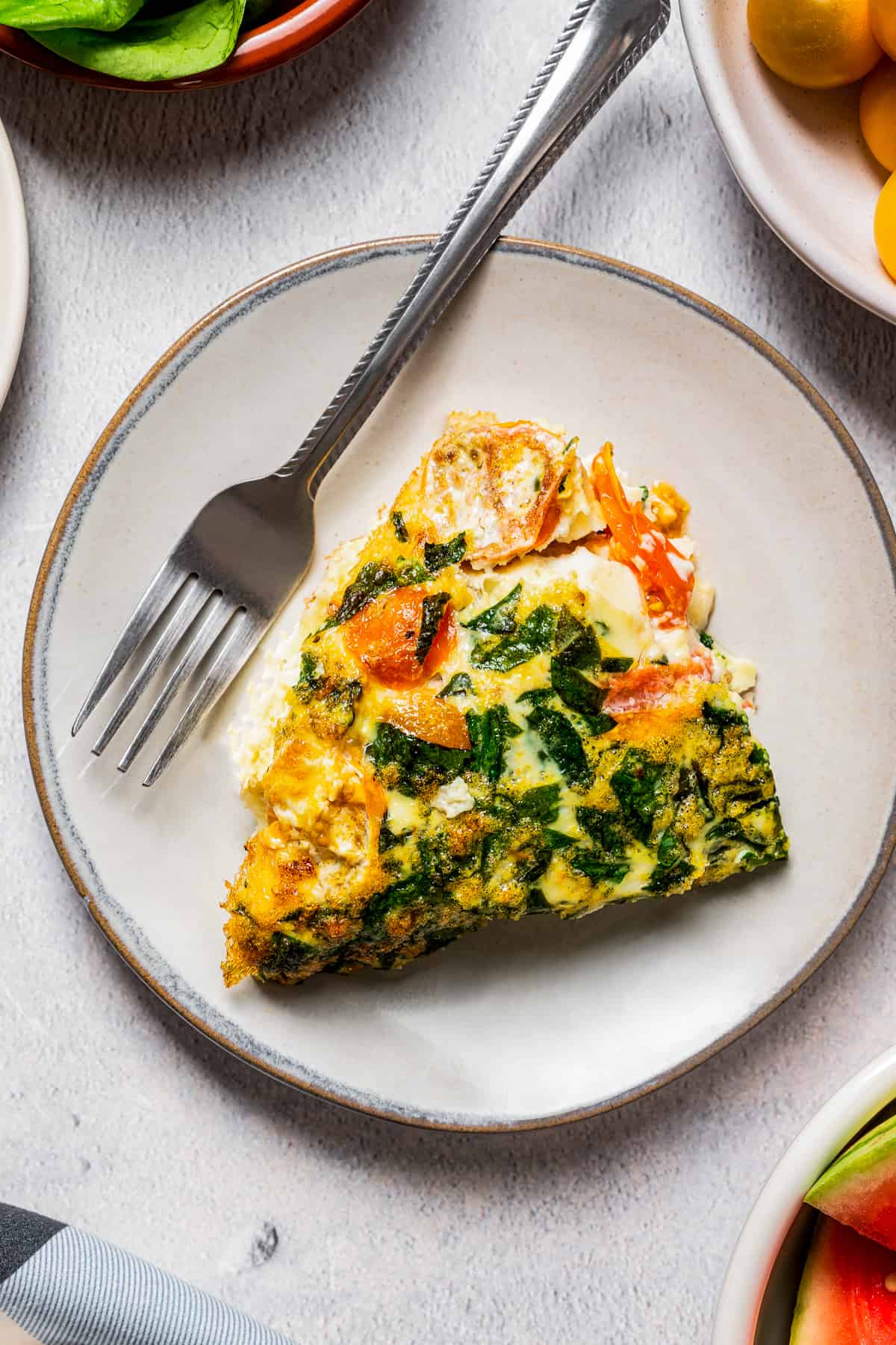 A slice of egg white frittata on a plate with a fork.