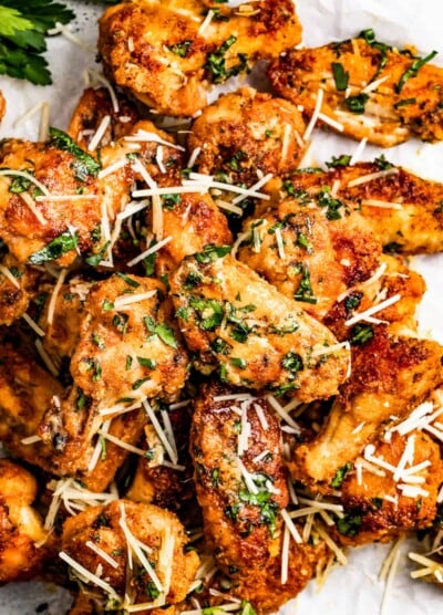 Garlic parmesan chicken wings garnished with parmesan cheese and parsley.