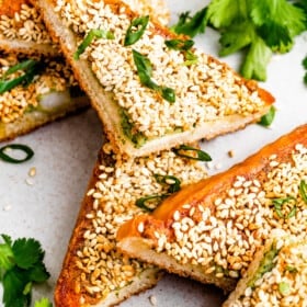 Overhead photo of shrimp toast triangles garnished with cilantro and scallions.