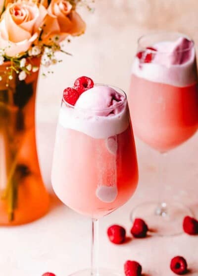 rose floats in wine glasses topped with sorbet and raspberries